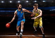 Two players dispute the ball during a basketball game.